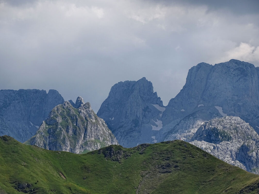 Pogled s grebena između Trojana i Popadije (nazire se dio toga grebena pod travom) na vrhove iz grupe Shkurt: Zastanski vrh (po dubini u sredini, lijevo), te u pozadini MajaVukoces, Preht i Lagojve.